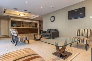 - un salon avec une table et des chaises en verre dans l'établissement Comfort Suites Downtown, à Montréal