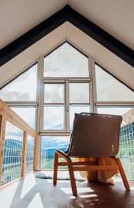 a chair in a room with a large window at Premium Design Ferienhäuser Mosel Chalets in Pommern