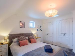 a bedroom with a large bed with pink pillows at Honey Bee House in Woodhall Spa