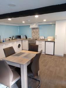 a kitchen with a table and chairs in a room at Pandy cymunod in Bryngwran
