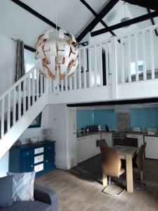 a living room with a staircase and a table and chairs at Pandy cymunod in Bryngwran