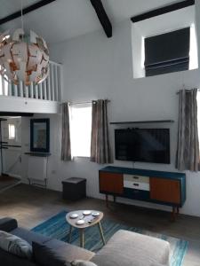 a living room with a couch and a tv at Pandy cymunod in Bryngwran