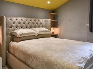 a bedroom with a large bed with a padded headboard at Doddick Beck - Uk39153 in Threlkeld