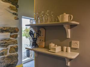 a shelf in a kitchen with dishes on it at Doddick Beck - Uk39153 in Threlkeld