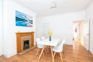 a dining room with a table and chairs and a fireplace at 4 bedroom house, 5 double beds and free parking. in Beeston