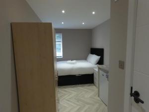 een kleine slaapkamer met een bed en een raam bij Cozzy in Londen