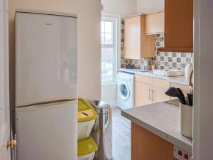 a kitchen with a refrigerator and a washer and dryer at Oakleigh By The Sea in Cromer