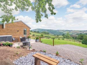 a log cabin with a bench in a yard at The Workshop in Garway