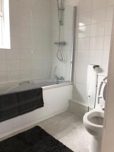 a bathroom with a bath tub and a toilet at Fully Detached Studio Annexe with Double Bed for 2 & Sofa Bed for 2 in Cambourne