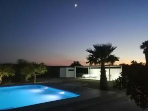 a house with a blue swimming pool at night at Villa private Siracusa luxury in Augusta