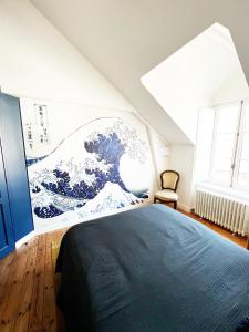 a bedroom with a large wave mural on the wall at Villa Sainte Claire in Saint Malo