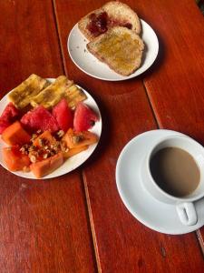 una mesa con dos platos de comida y una taza de café en Pousada São Jorge, en Bonito