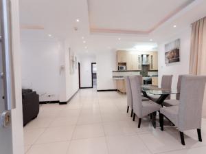 a dining room and kitchen with a table and chairs at Unit 5, Capella Place in Accra
