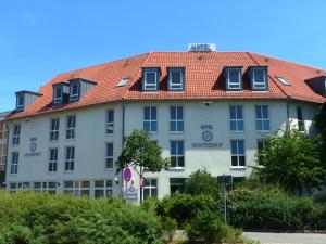 ein großes weißes Gebäude mit einem roten Dach in der Unterkunft Hotel Dorotheenhof in Cottbus