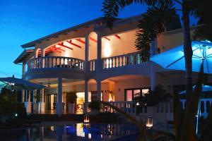 une grande maison avec une piscine en face de celle-ci dans l'établissement Petit Amour Villa, Seychelles, à Victoria