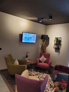 ein Wartezimmer mit Stühlen und einem Flachbild-TV in der Unterkunft Hotel Dein Franz in Bad Füssing