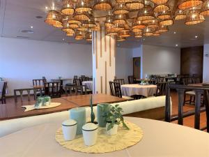 a dining room with tables and chairs and a chandelier at Quinta Da Penha De Franca in Funchal