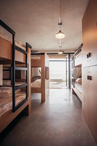 a room with several bunk beds and a hallway at MUTE Hostel Porto Covo in Porto Covo