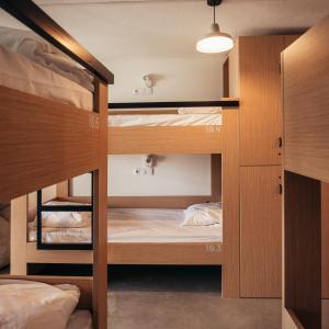 a room with two bunk beds and a lamp at MUTE Hostel Porto Covo in Porto Covo