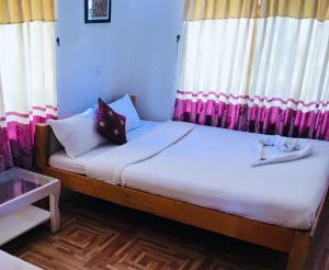 una piccola camera da letto con letto con tende rosa di Hotel Buddha Land a Pokhara