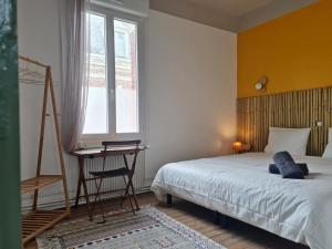a bedroom with a bed and a desk and a window at Les 3 Graces, Cayeux-sur-mer, agréable maison in Cayeux-sur-Mer