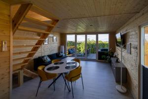 a living room with wooden ceilings and a table and chairs at Domki Kunice in Kunice