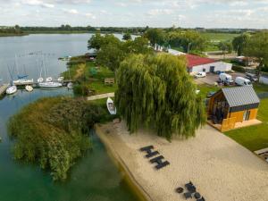 an aerial view of a lake with a house and boats at Domki Kunice in Kunice