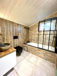 a bathroom with a tub and a sink and a window at The Cottage in Bocholt