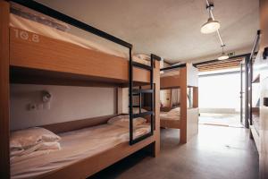 a room with three bunk beds in a room at MUTE Hostel Porto Covo in Porto Covo