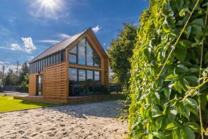 a house clad in wood and glass at Domki Kunice in Kunice +19 photos