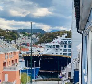 a large cruise ship docked in a harbor at Apartments At The Sentrum in Kristiansund
