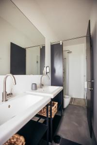 a bathroom with two sinks and a mirror at MUTE Hostel Porto Covo in Porto Covo