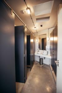 uma casa de banho com dois lavatórios e dois espelhos em MUTE Hostel Porto Covo em Porto Covo