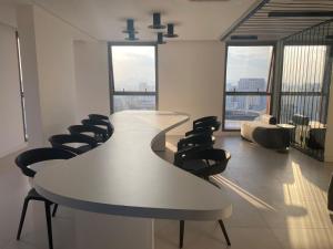 una sala de reuniones con mesa blanca y sillas en Studio moderno a 5min a pé do Allianz Parque, en São Paulo