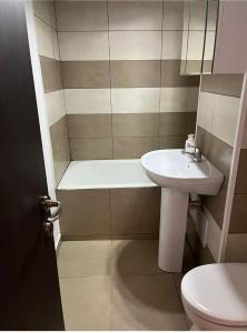 a bathroom with a sink and a tub and a toilet at Kevin's Guest House in Brăila