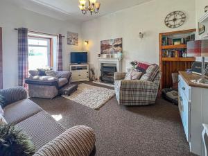 a living room with two couches and a fireplace at Cuillin Cottage in Arnisdale