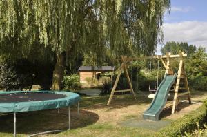 um parque infantil com um escorrega e um baloiço em Villa Martensplek met sauna em Tiendeveen