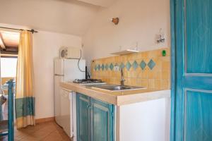 uma cozinha com um lavatório e um frigorífico em Casa Gallo em Marinella