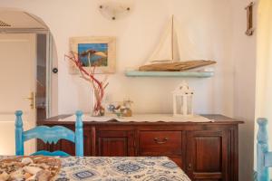 een slaapkamer met een houten dressoir met een modelboot erop bij Casa Gallo in Marinella