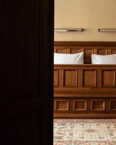 sypialnia z drewnianym łóżkiem z białymi poduszkami w obiekcie Hotel Copernicus w Krakowie