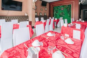 ビエンチャンにあるView Hotel Vientianeの赤いテーブルと白い椅子が備わるダイニングルーム
