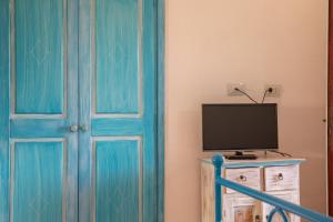 a room with a blue door and a television at Casa Gallo in Santa Marinella