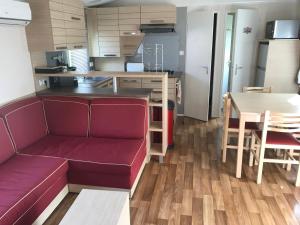 ein Wohnzimmer mit einem roten Sofa und einer Küche in der Unterkunft Le Mill in Meilhan