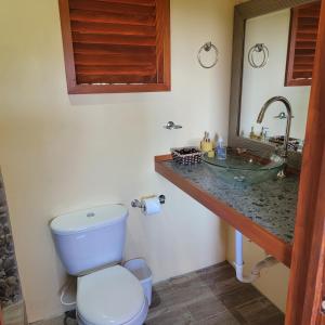 a bathroom with a toilet and a sink at Tropical Paradise View in Anse La Raye