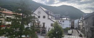 a white building with a clock on the side of it at Casa Robelca in Biescas