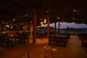 um restaurante vazio com mesas e cadeiras à noite em SAMA Ras Al Jinz Resort em Sur