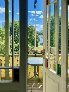 a view from the door of a balcony with a table at Historic apartment near the city by the water in Solna