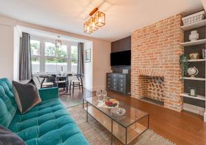 布萊頓霍夫的住宿－V Villas，客厅设有蓝色的沙发和砖砌壁炉