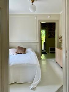 1 dormitorio con 1 cama blanca en una habitación en Historic apartment near the city by the water, en Solna