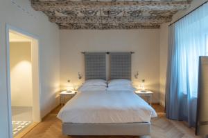 ein Schlafzimmer mit einem großen Bett mit zwei Tischen in der Unterkunft CASPAR Swiss Quality Hotel in Muri